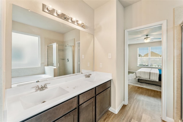 bathroom with vanity, ceiling fan, plus walk in shower, and wood-type flooring