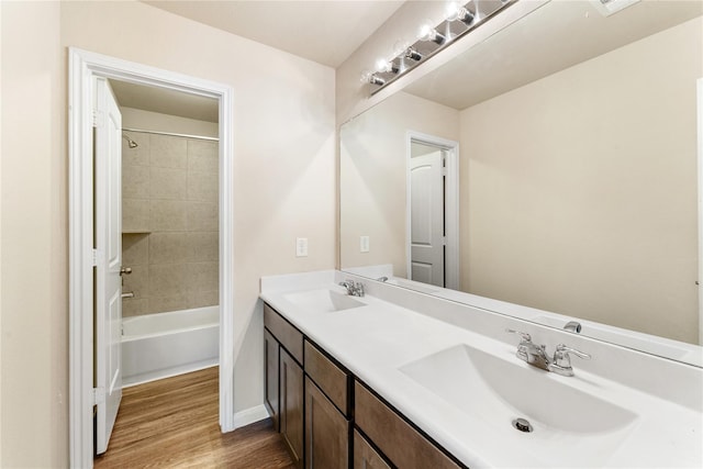 bathroom with vanity, hardwood / wood-style flooring, and tiled shower / bath combo