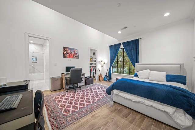 bedroom featuring ensuite bathroom and wood-type flooring