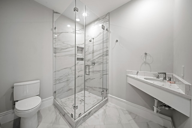 bathroom featuring toilet, a shower with shower door, and sink