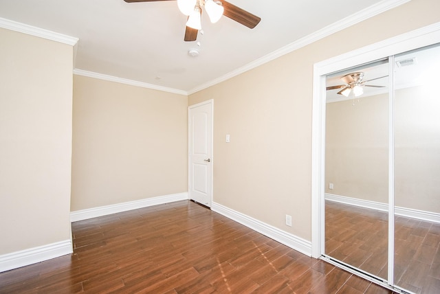 empty room with dark hardwood / wood-style flooring, ornamental molding, and ceiling fan