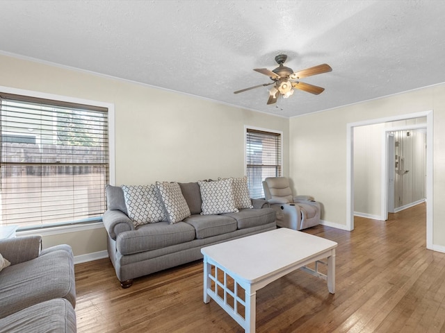 living room featuring hardwood / wood-style flooring, plenty of natural light, ceiling fan, and a textured ceiling