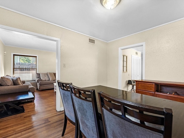 dining space featuring dark hardwood / wood-style floors and crown molding