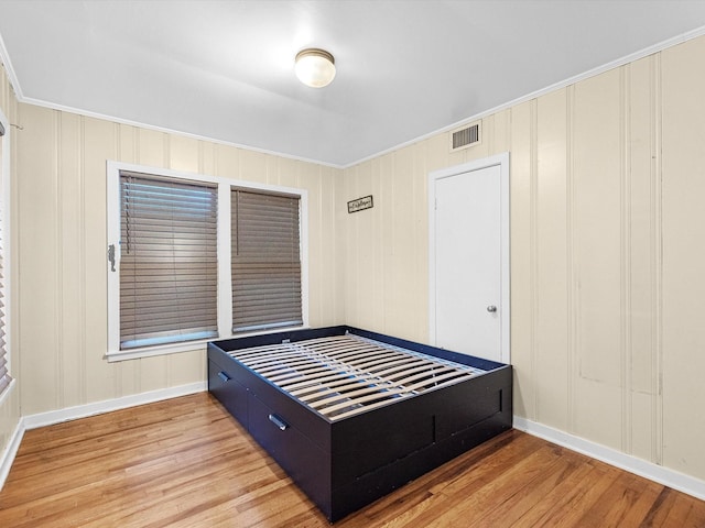 bedroom featuring crown molding and wood-type flooring