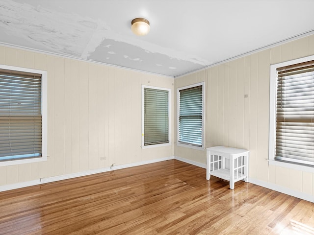 spare room featuring light wood-type flooring and crown molding