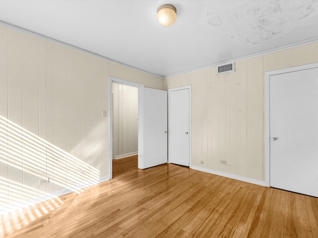 unfurnished room with crown molding and wood-type flooring