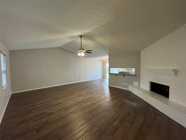 unfurnished living room with a textured ceiling, ceiling fan, dark wood-type flooring, a fireplace, and lofted ceiling