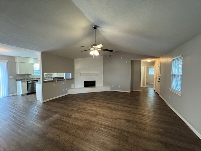 unfurnished living room with ceiling fan, dark hardwood / wood-style flooring, a textured ceiling, lofted ceiling, and a fireplace