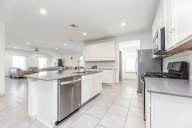 kitchen featuring sink, white cabinetry, stainless steel appliances, and a kitchen island with sink