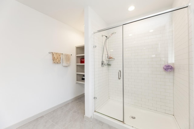 bathroom with tile patterned flooring and a shower with shower door