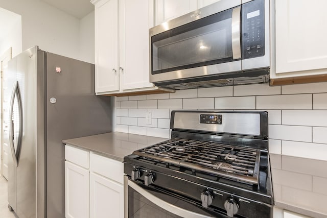 kitchen featuring backsplash, white cabinetry, and stainless steel appliances