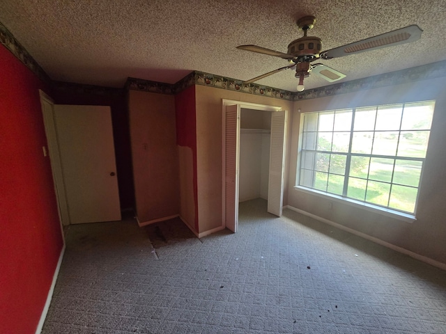 unfurnished bedroom featuring carpet flooring, ceiling fan, a closet, and a textured ceiling