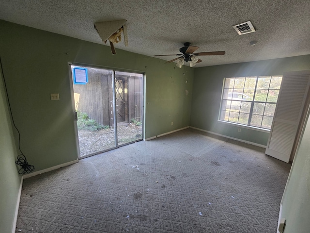 unfurnished room featuring ceiling fan and a textured ceiling