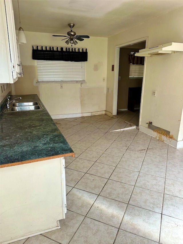 kitchen with ceiling fan, light tile patterned flooring, white cabinetry, and sink