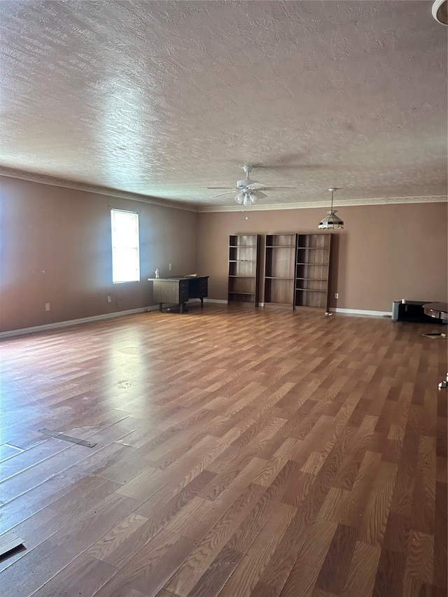 unfurnished living room with hardwood / wood-style floors, ceiling fan, ornamental molding, and a textured ceiling