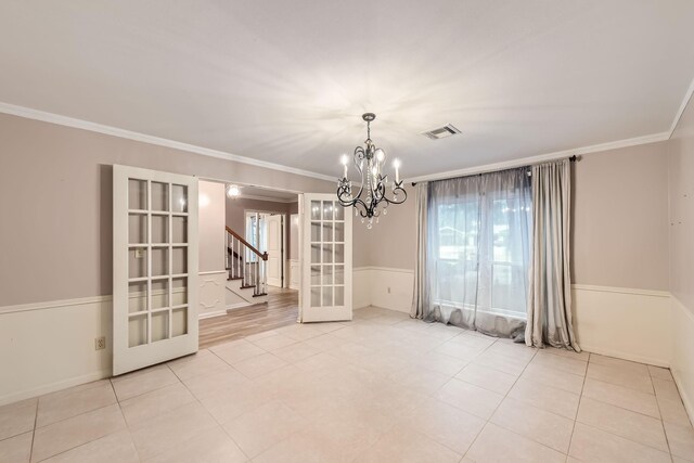 tiled spare room featuring french doors, an inviting chandelier, and ornamental molding