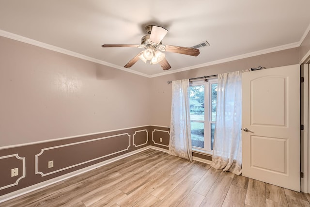 empty room with ceiling fan, light wood-type flooring, and crown molding