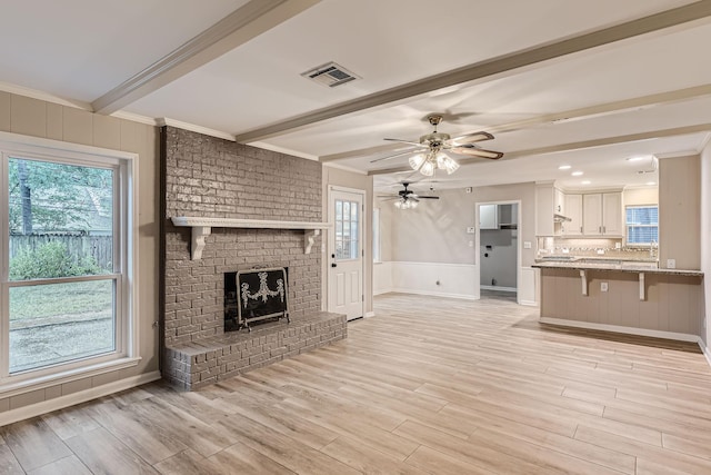 unfurnished living room featuring a wealth of natural light, a fireplace, and light hardwood / wood-style flooring