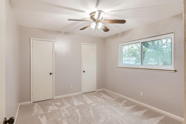 unfurnished bedroom with ceiling fan and light colored carpet