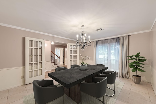 tiled dining room with crown molding, french doors, and a notable chandelier