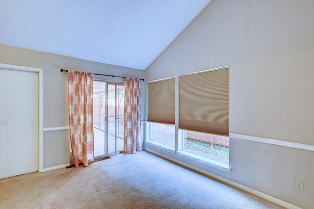 empty room featuring light carpet and high vaulted ceiling