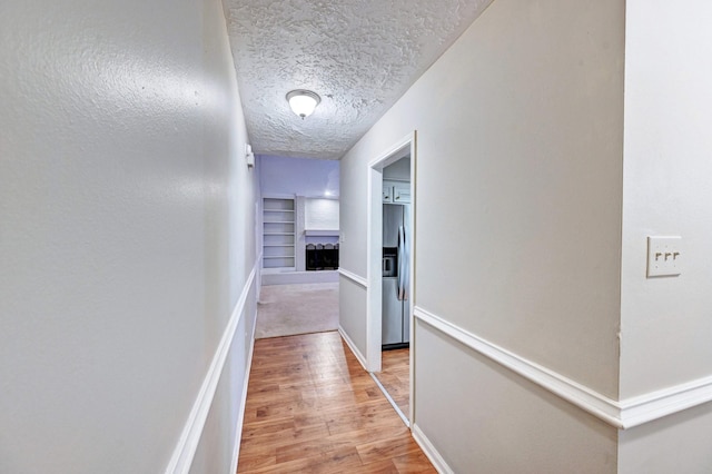 hall featuring a textured ceiling and hardwood / wood-style flooring