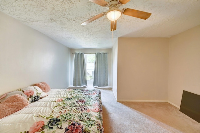 bedroom with ceiling fan, carpet, and a textured ceiling