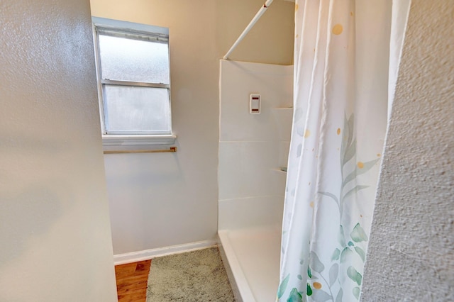 bathroom with a shower with shower curtain and hardwood / wood-style flooring