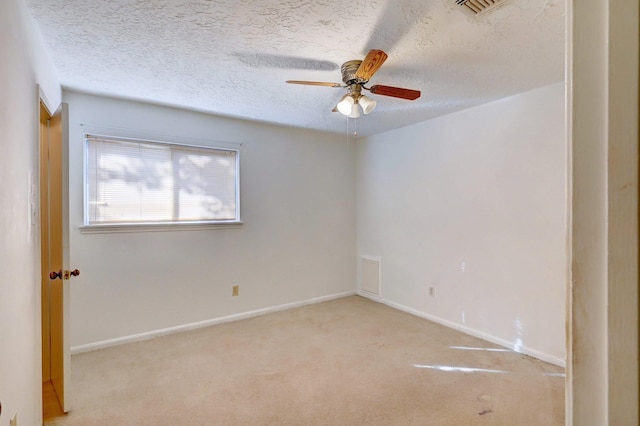 carpeted empty room with ceiling fan and a textured ceiling