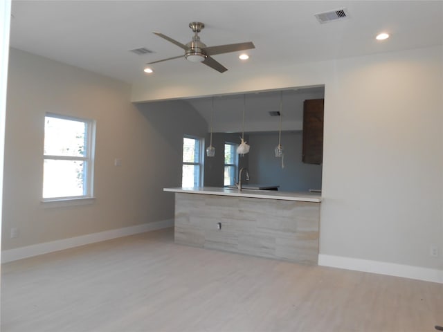 kitchen featuring sink, light wood-type flooring, hanging light fixtures, and ceiling fan