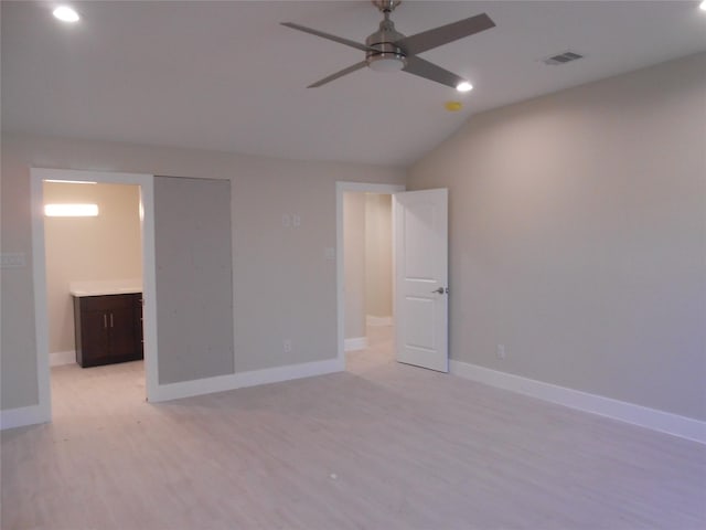 unfurnished bedroom featuring light wood-type flooring, ensuite bathroom, ceiling fan, and lofted ceiling