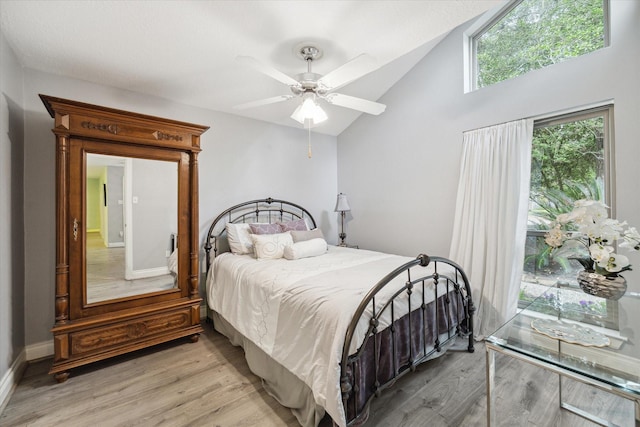 bedroom featuring light wood-type flooring, vaulted ceiling, and ceiling fan