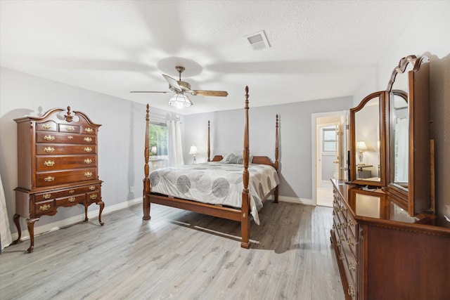 bedroom with ceiling fan, a textured ceiling, and light hardwood / wood-style flooring