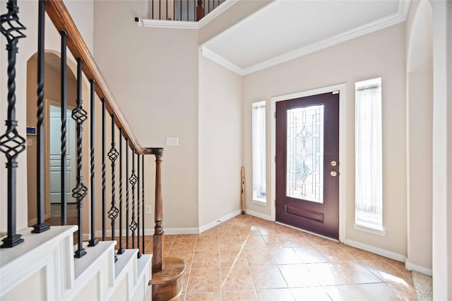 foyer entrance featuring a healthy amount of sunlight, ornamental molding, and light tile patterned floors