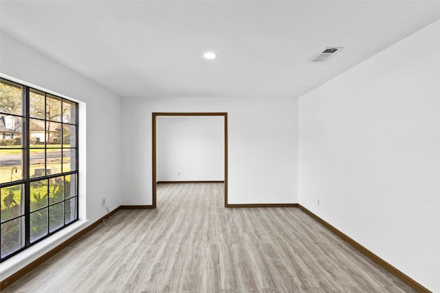 spare room with plenty of natural light and light hardwood / wood-style floors