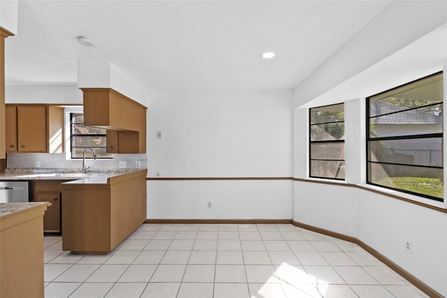 kitchen featuring dishwasher, light tile patterned floors, a healthy amount of sunlight, and sink