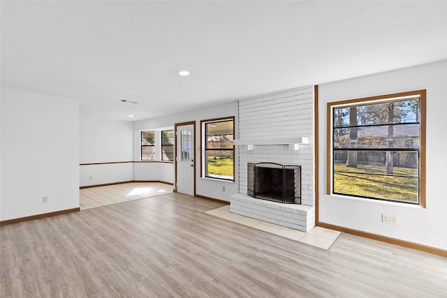 unfurnished living room with a fireplace and light hardwood / wood-style floors