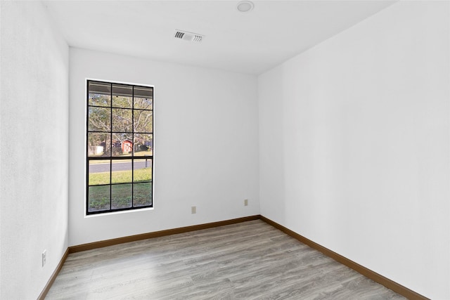 empty room featuring a wealth of natural light and light wood-type flooring