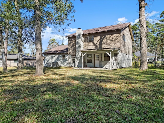 rear view of property featuring a lawn