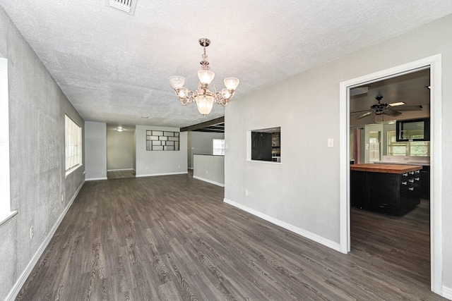 unfurnished living room with dark hardwood / wood-style floors, a textured ceiling, and ceiling fan with notable chandelier