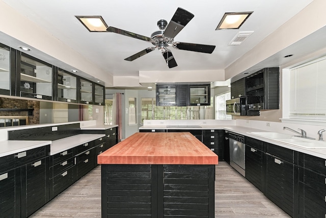 kitchen with a center island, wooden counters, sink, light hardwood / wood-style floors, and stainless steel appliances