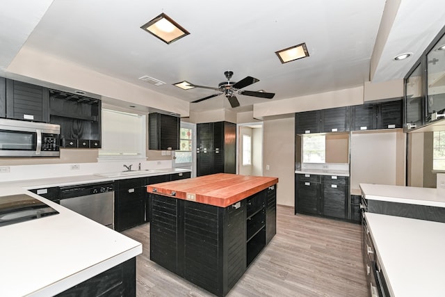 kitchen featuring wood counters, a center island, light wood-type flooring, and stainless steel appliances