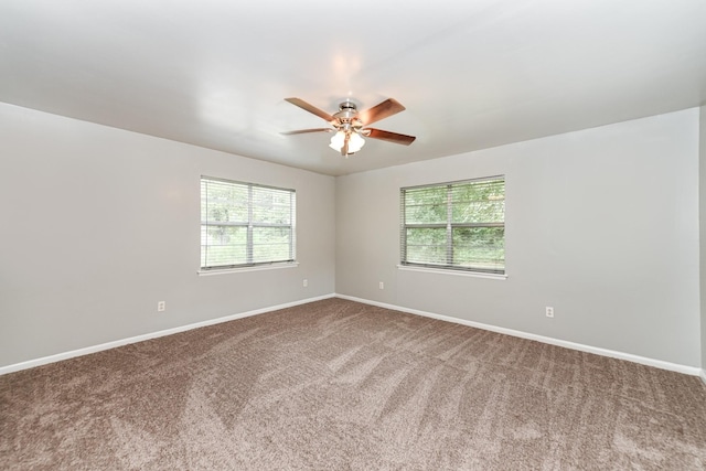 carpeted spare room with plenty of natural light and ceiling fan