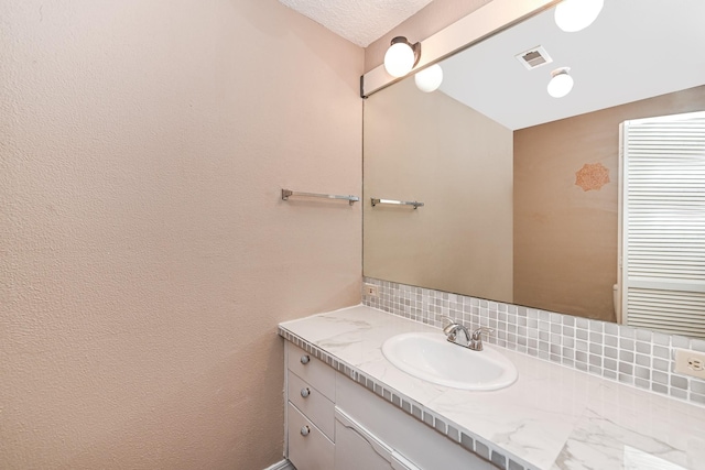 bathroom featuring vanity and backsplash