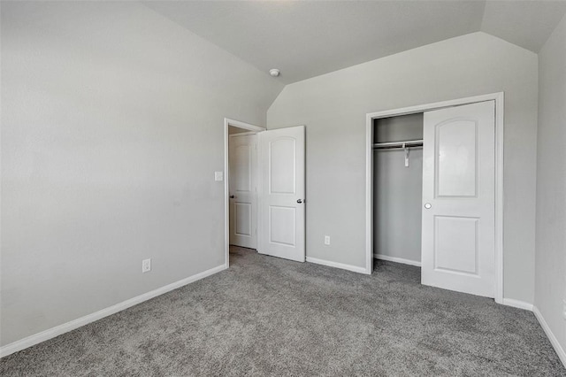 unfurnished bedroom featuring a closet, carpet floors, and lofted ceiling