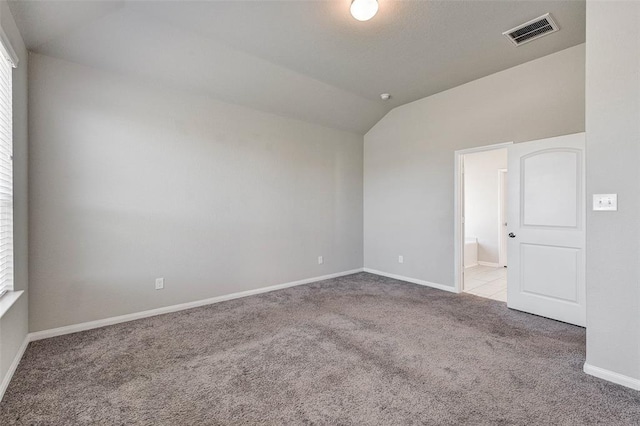 unfurnished room with light carpet and vaulted ceiling