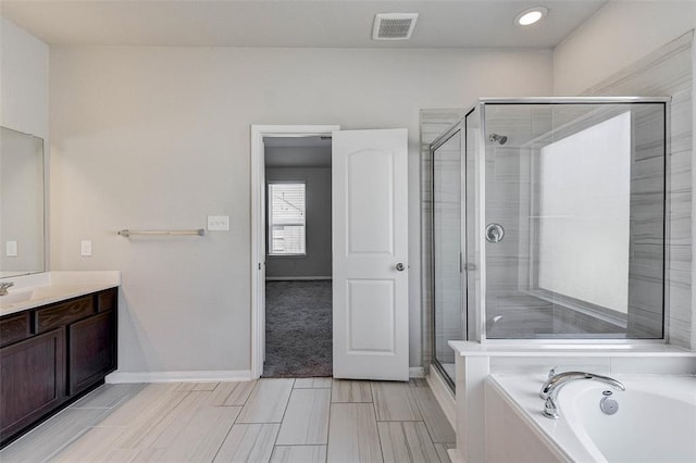 bathroom featuring plus walk in shower and vanity