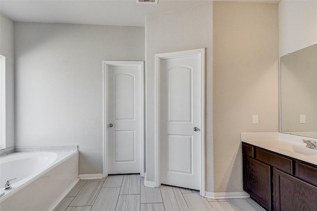 bathroom with vanity and a tub to relax in