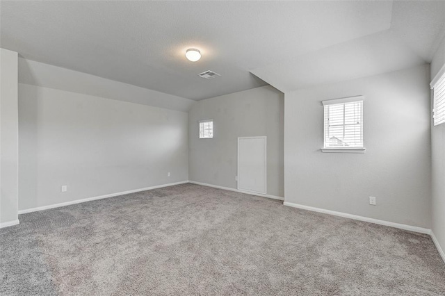 interior space with carpet flooring and vaulted ceiling