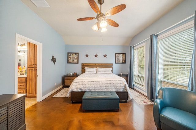 bedroom featuring ceiling fan, ensuite bathroom, and lofted ceiling